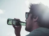homem tomando cerveja de uma garrafa da heineken, que está na lista da cerveja mais vendida do mundo