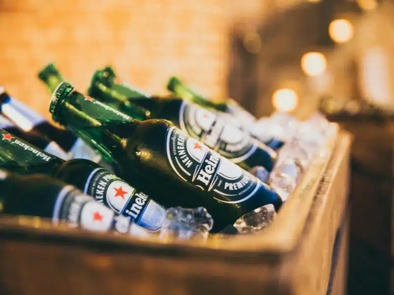 garrafas de uma das marcas de cerveja heineken em caixa com gelo