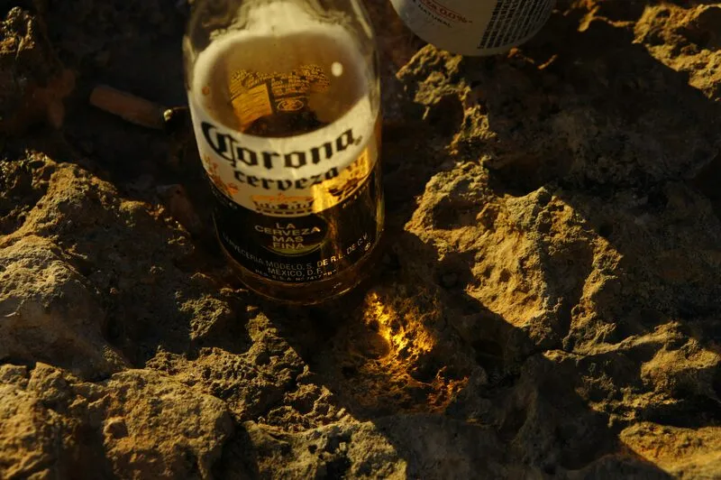 garrafa da corona, melhor cerveja low carb, em cima de areia