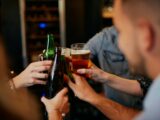 Grupo de amigos brindando com cervejas em copos e garrafas
