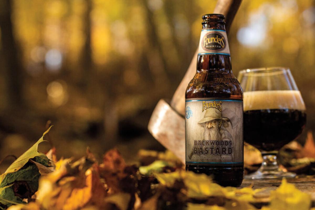 Esta imagem retrata uma cena rústica e outonal que destaca uma cerveja artesanal de estilo robusto e envelhecida em barril.