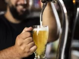 homem que calculou a quantidade de chopp por pessoa enche caneca de cerveja