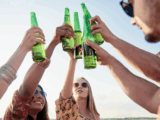 jovens tomam estilos de cerveja refrescantes para o verão e brindam garrafas