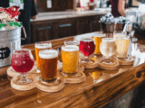 A imagem que você compartilhou mostra uma variedade de cervejas artesanais dispostas em uma tábua de degustação, cada uma com uma cor e aparência distintas. Cervejas artesanais frequentemente são conhecidas por usar ingredientes exóticos e incomuns para adicionar sabores e aromas únicos.