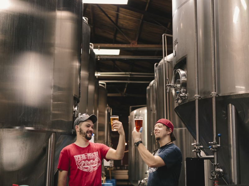 dois funcionários de uma das cervejarias pelo mundo analisando cervejas no copo