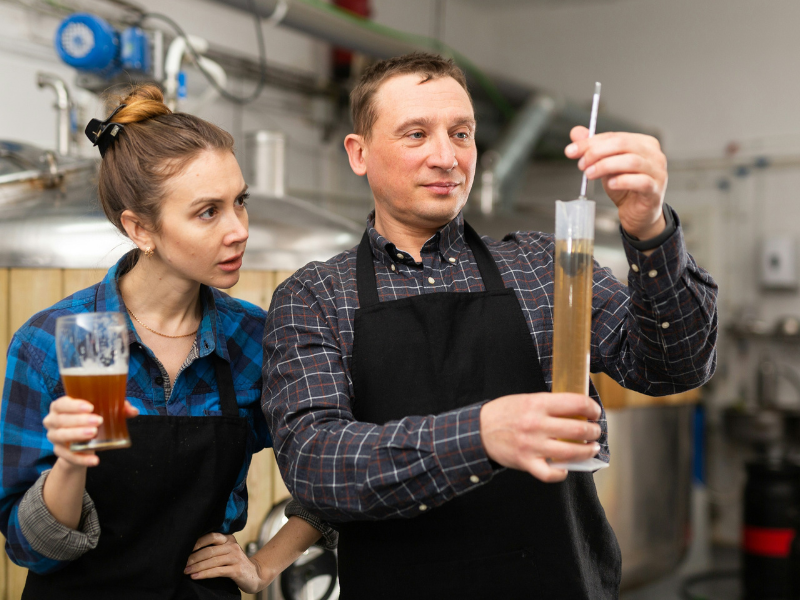funcionários de uma das cervejarias pelo mundo analisando o nível de álcool de uma cerveja